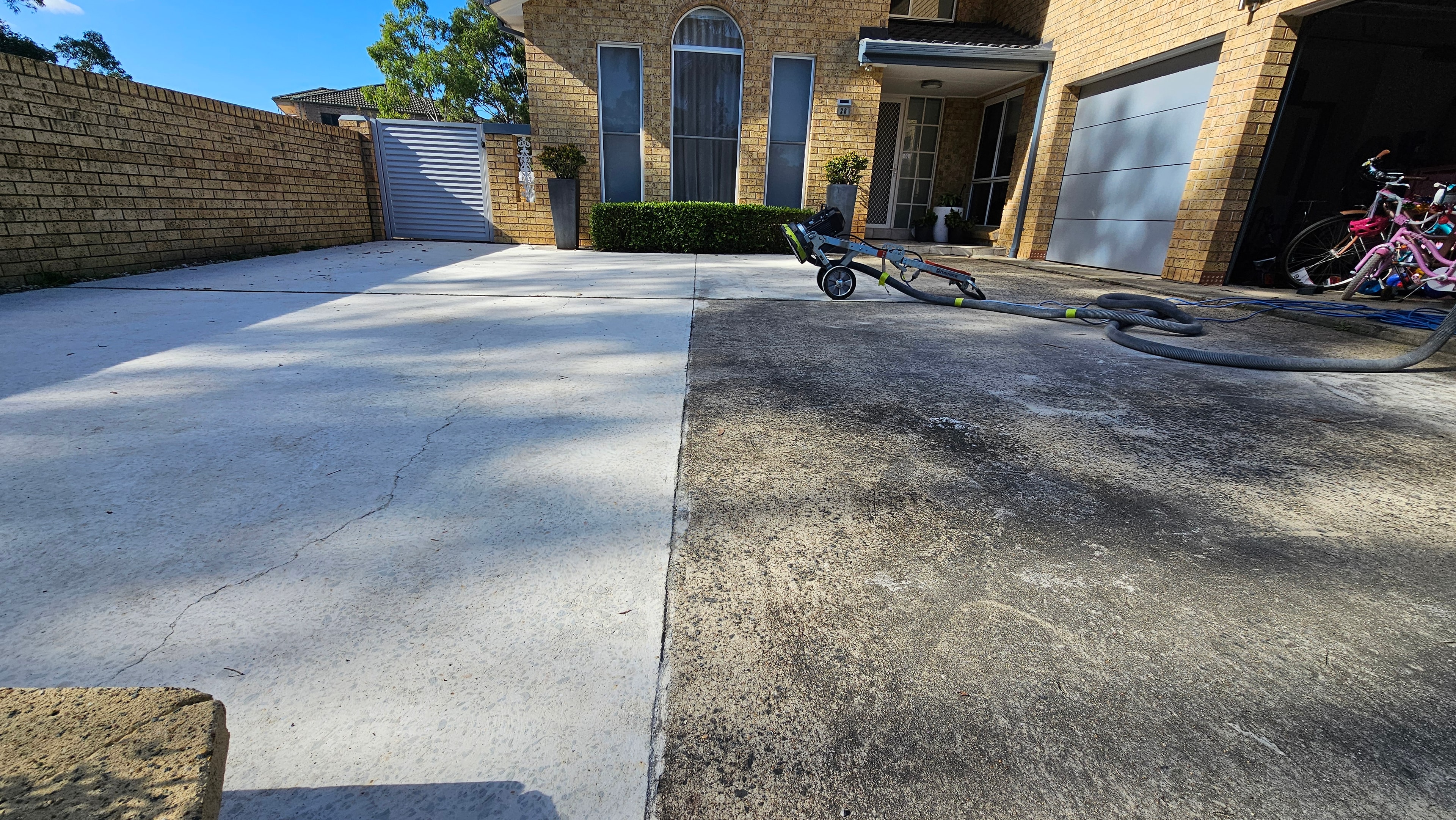 Driveway during concrete grinding — half ground half original